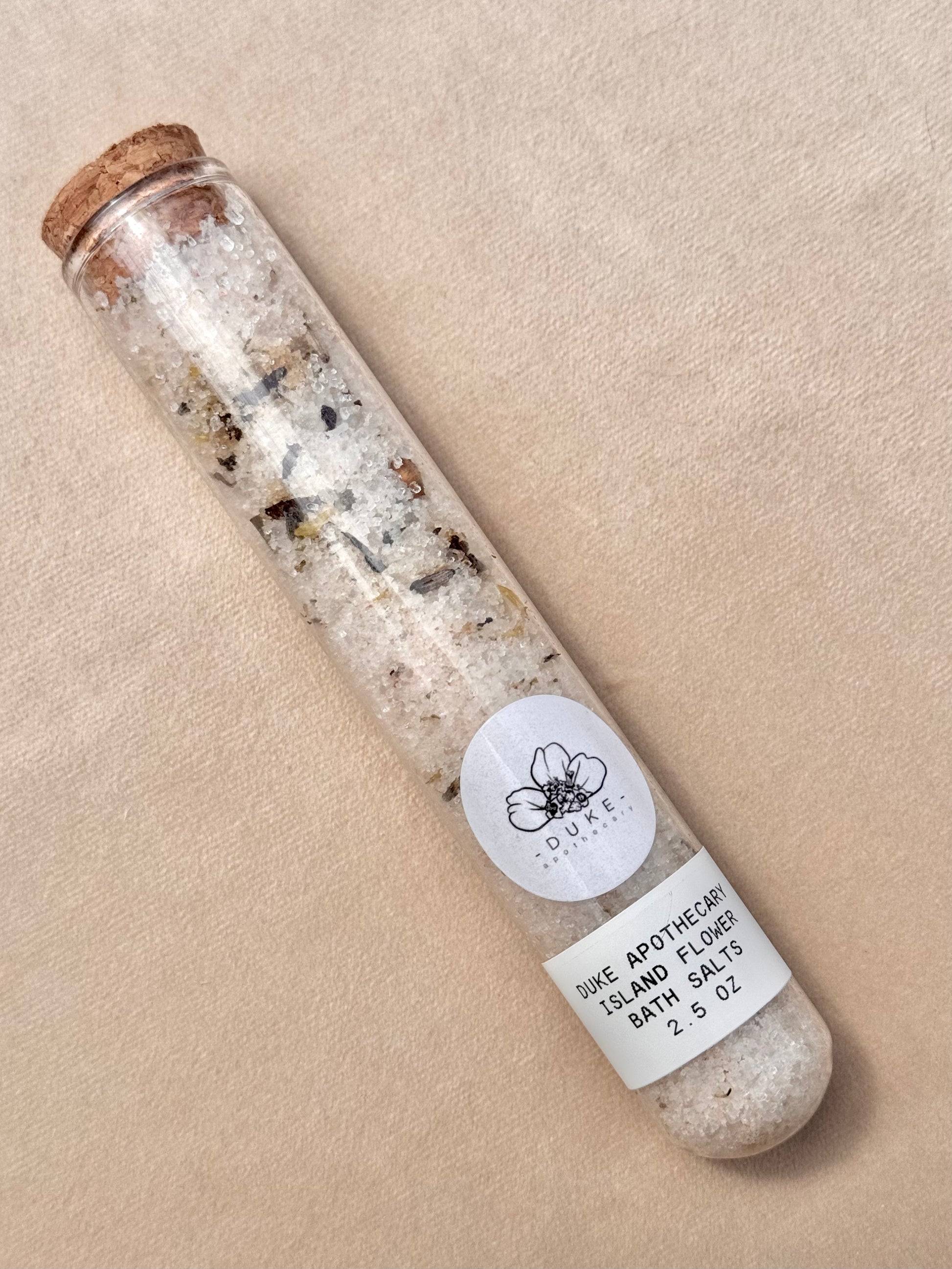 Bath salts in a glass tube with cork lid on a beige background