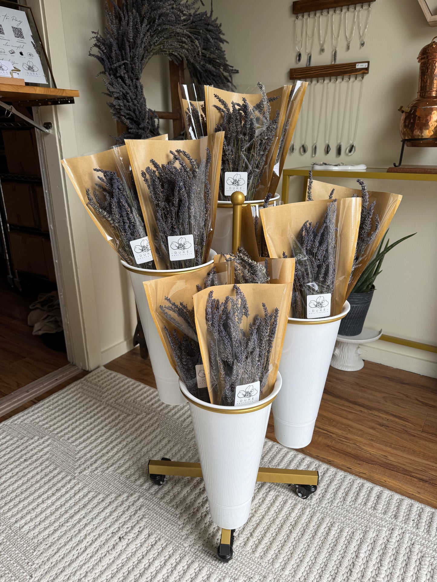 Cones filled with dried lavender on a rotating stand in a store setting.
