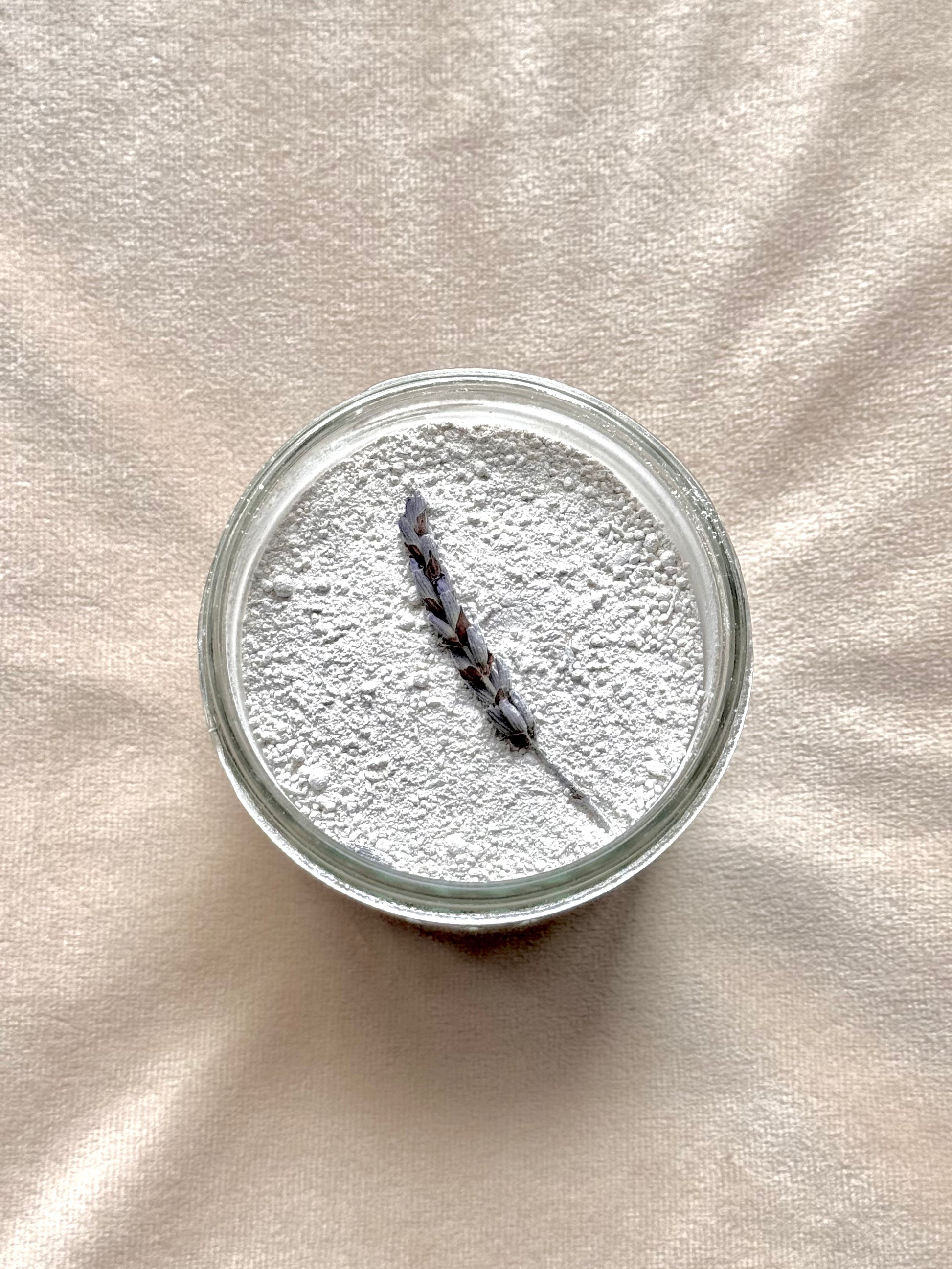 Glass jar with lavender on a beige fabric background