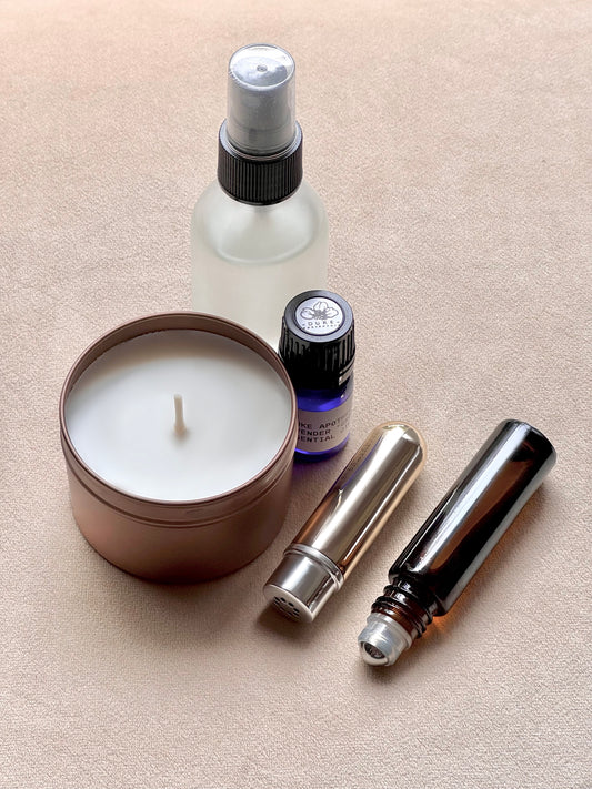 Candle, spray bottle, and essential oil bottles on a beige surface