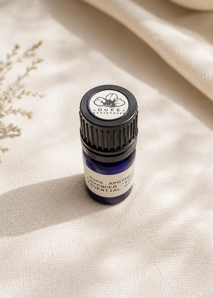 Essential oil bottle labeled 'Duke Apothecary' on a beige fabric background