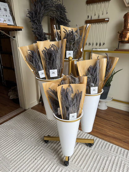 Cones filled with dried lavender on a rotating stand in a store setting.