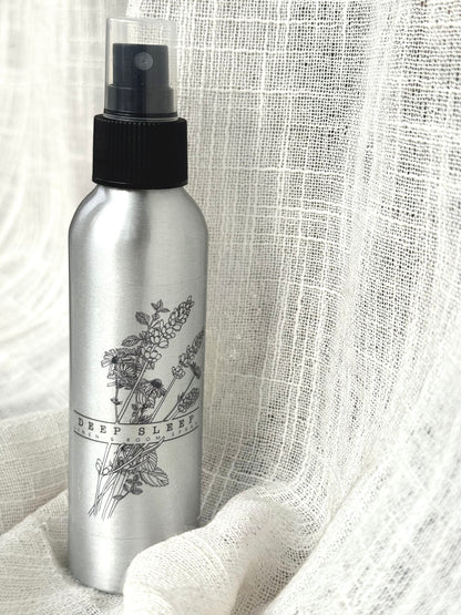 Silver spray bottle with black label on a textured white background