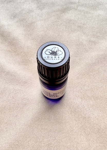 Duke Apothecary essential oil bottle on fabric beige background