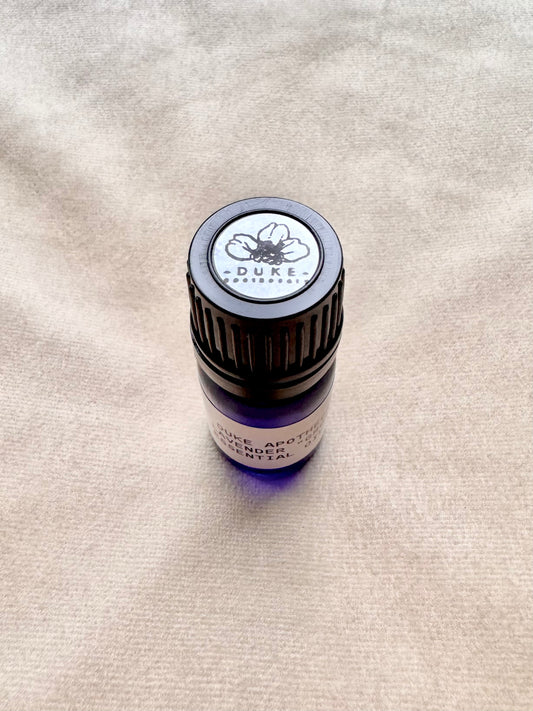 Duke Apothecary essential oil bottle on fabric beige background