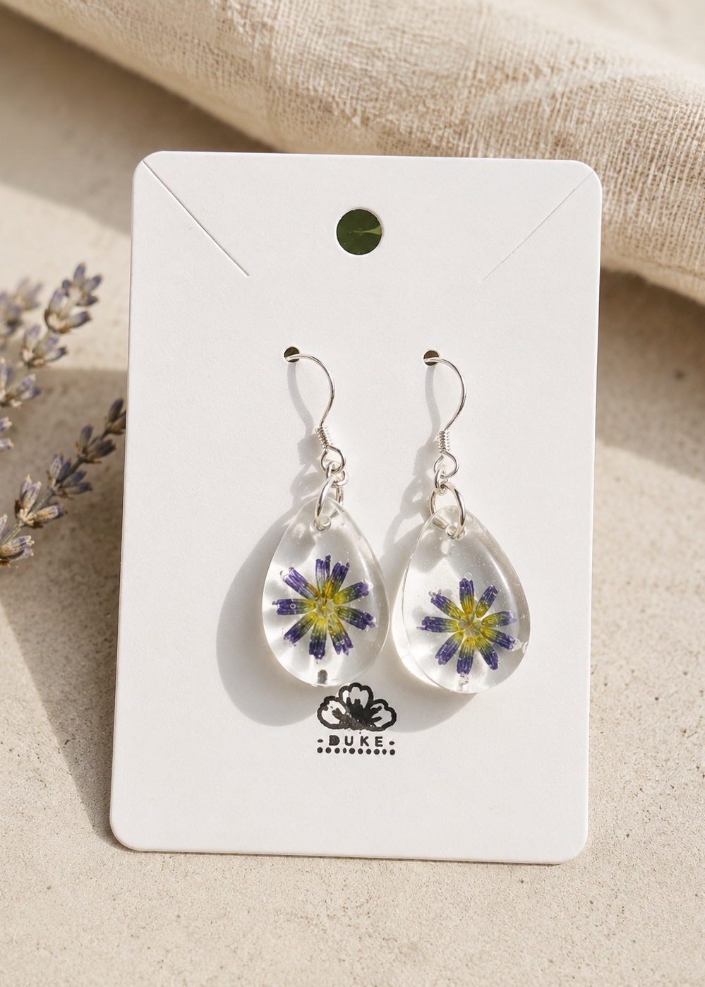 Teardrop-shaped earrings with floral design on a Duke & Duchess card.